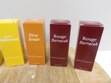 four boxes of perfume sitting on top of a wooden table