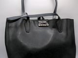 a black leather handbag with a silver buckle on the handle