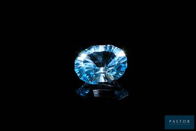 a close up of a blue diamond on a black surface