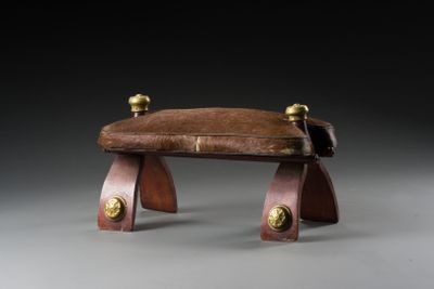 an image of a wooden bench with a leather seat on it