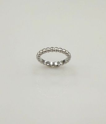 une bague ornée de perles argentées sur un fond blanc