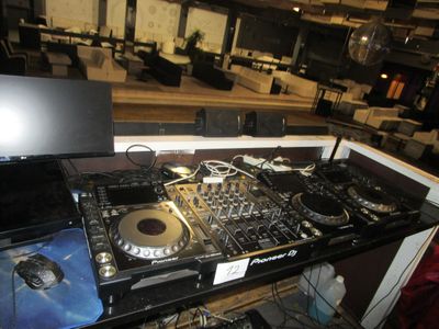 une table sur laquelle sont posés un équipement de DJ et un ordinateur portable
