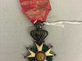 une image représentant une médaille ornée d'un ruban rouge et d'une étoile