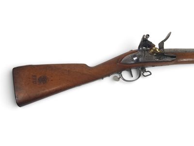 un vieux pistolet avec une crosse et un canon en bois