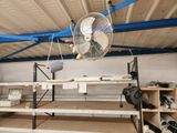 a fan that is hanging from the ceiling in a garage