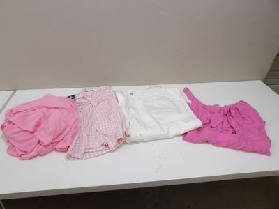 un tas de vêtements posé sur une table blanche dans une pièce