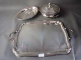 two silver trays on a table with a silver lid and a silver tray with a silver lid