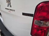 a close up of a white truck with a red tail light