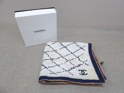 a white and blue blanket and a box on a bed