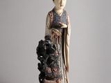 chinese figurine of a woman with a dog on a stool