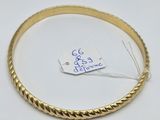 a close up of a gold bracelet with a tag on it