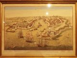 tableau représentant une vue de ville avec des bateaux au premier plan