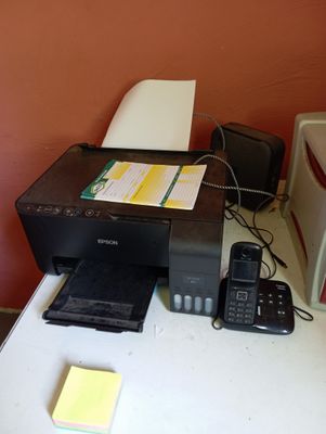 a printer and a cell phone sitting on a desk