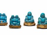 four blue buddha figurines are sitting on a gold stand
