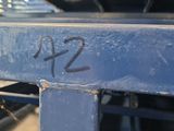 a close up of a blue metal bench with graffiti on it