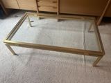 une table basse en verre surmontée d'un cadre doré
