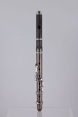 a close up of a silver and black clarinet on a clear surface