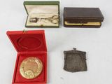 plusieurs petits objets métalliques, dont une médaille en or, un portefeuille et un sac à main