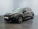 Une voiture grise est garée dans une pièce aux murs blancs.