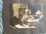 an old photo of a man sitting at a desk with a typewriter