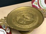 a gold plate with a picture of a dragon on it