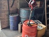 un fût rouge posé sur une palette dans un garage