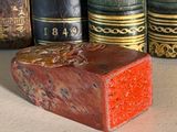 a small wooden block sitting on a table next to a row of books