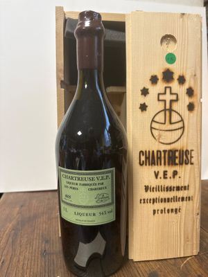 la bouteille de vin se trouve à côté d'un coffret en bois sur une table