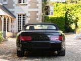 a black car parked in front of a large house