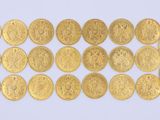 un groupe de pièces d'or posées sur une surface blanche