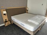 a bed with a wooden head board and a night stand