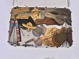 a metal box filled with assorted items on a white surface