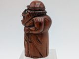 an old wooden figurine of a man with a hat on his head