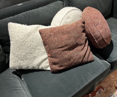 deux oreillers et un coussin posés sur un canapé dans un salon