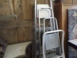 une pile d'échelles et une chaise dans une pièce