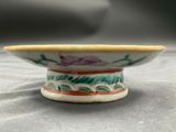 a small bowl sitting on a table with a flower design on it