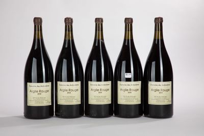 quatre bouteilles de vin sont alignées sur une surface blanche