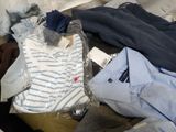 a pile of clothes sitting on top of a bed