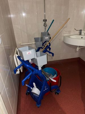 une petite salle de bains avec une serpillière et des seaux à l'intérieur