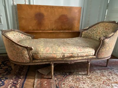 a chaise lounger in a room with a rug on the floor