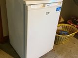 an image of a small white refrigerator in a room