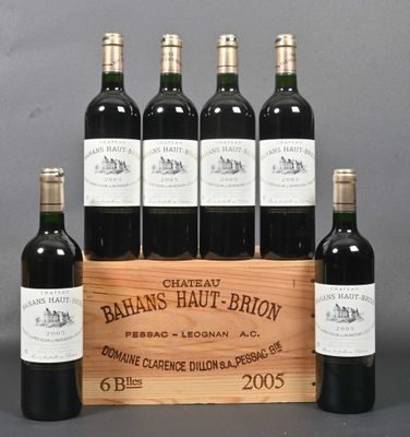 six bottles of red wine in a wooden crate on a table