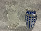 two glass vases sitting next to each other on a gray surface