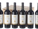 six bouteilles de vin rouge sont alignées devant une caisse en bois