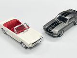 deux voitures jouets assises l'une à côté de l'autre sur une surface blanche