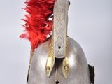 a silver helmet with a red feather on top of it