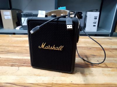 a marshall amplifier sitting on top of a wooden table