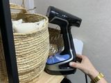 quelqu'un utilise un sèche-cheveux pour sécher des vêtements posés sur une étagère