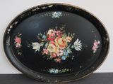 a black tray with flowers on it on a table