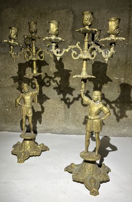 paire de candélabres anciens en laiton ornés de figurines sur des socles